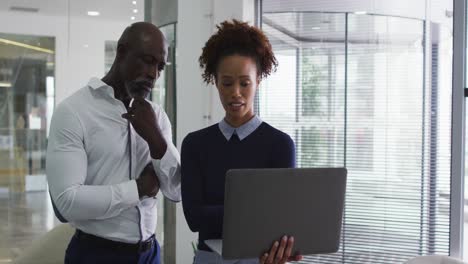 diversos colegas de negocios masculinos y femeninos hablando, una mujer con una computadora portátil en la oficina