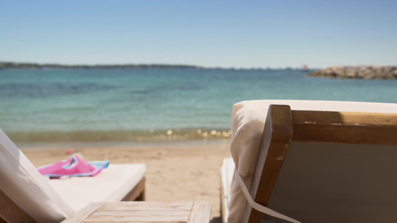 Relaxing beachfront view framed by comfortable lounge chairs facing the turquoise sea