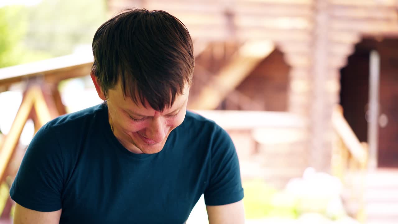 클로즈업 그 남자는 필라프를 요리하고 있다. 그는 여름 집에 있다. 채소를 잘라 웃고 있다.