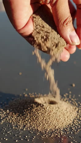 hand pouring sand
