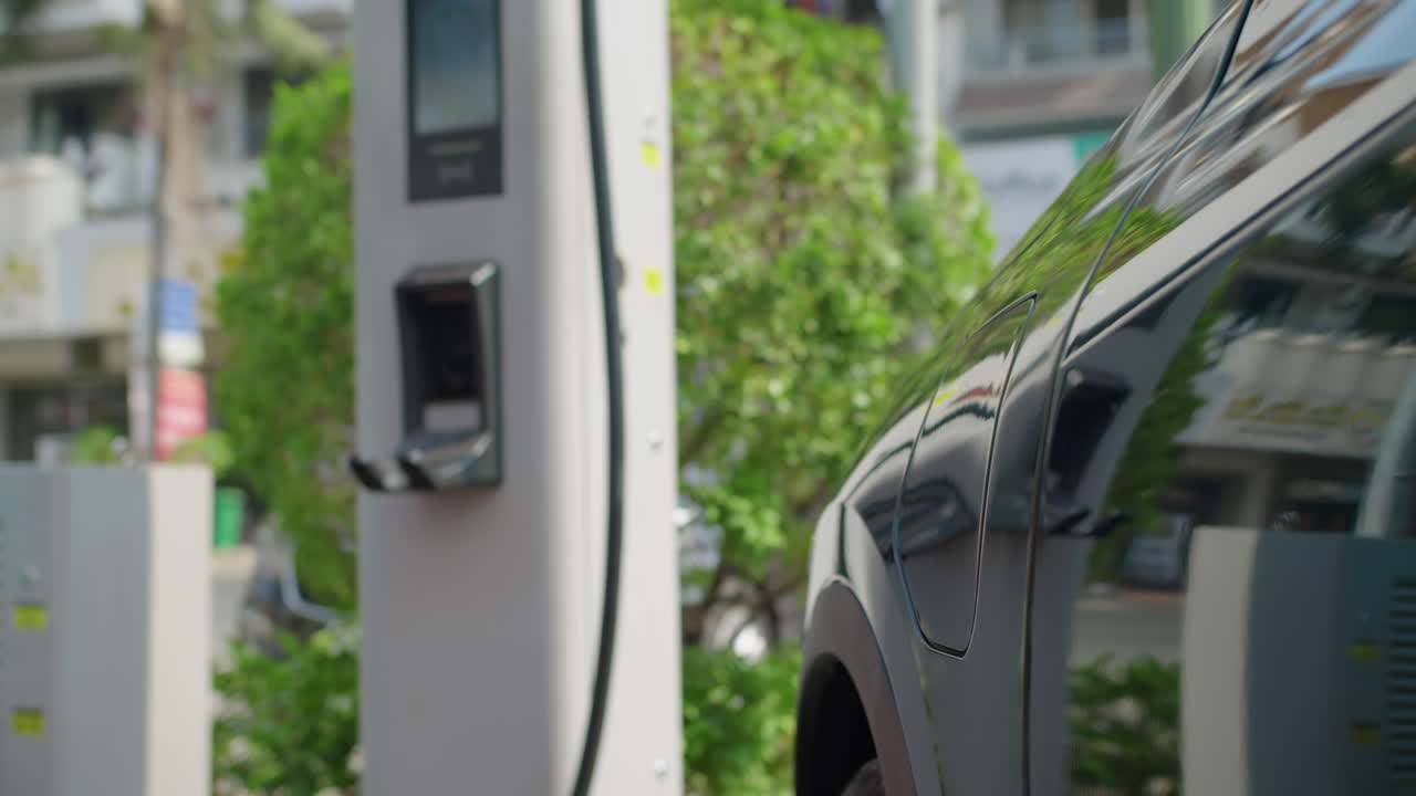 женщина заряжает электромобиль