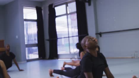 multi-ethnic group of fit male and female modern dancers practicing a dance routine