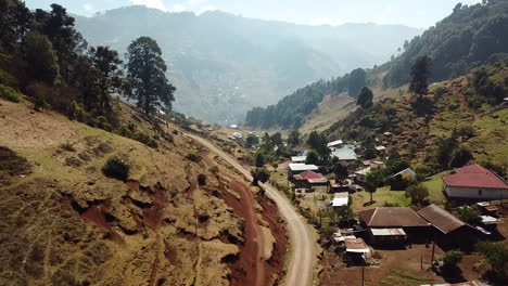 Aerial-shot-of-houses-between-mountains-in-Nebaj,-Quiche-in-Guatemala