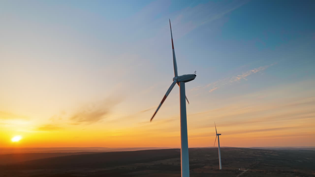 Vista aerea in timelapse di un drone di una turbina eolica funzionante. Tramonto sul sole sullo sfondo