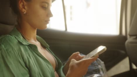 Woman using mobile phone in car