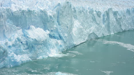 melting ice from glacier falling into fjord water