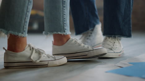 couple legs making steps on floor. man and woman feet dancing during repair.