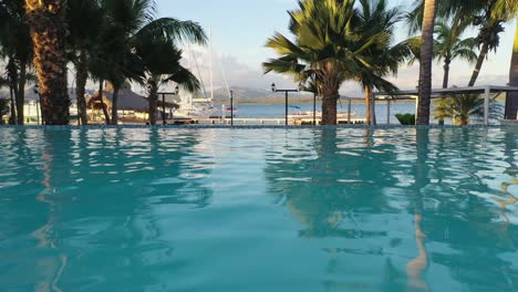 Drone-flying-over-resort-pool-at-Bahia-de-las-Calderas,-Dominican-Republic