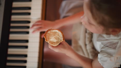close up aerial view of young girl eating ice cream cone while playing piano, showcasing childlike multitasking, relaxed creativity, and innocent delight in cozy home environment