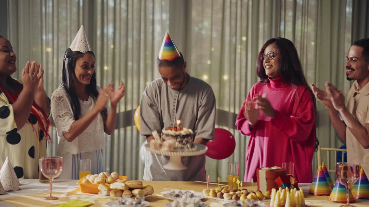 Diverse group of friends celebrating a birthday party with cake and applause
