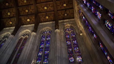 cathedral ceiling with stained glass windows and wooden ceiling panels
