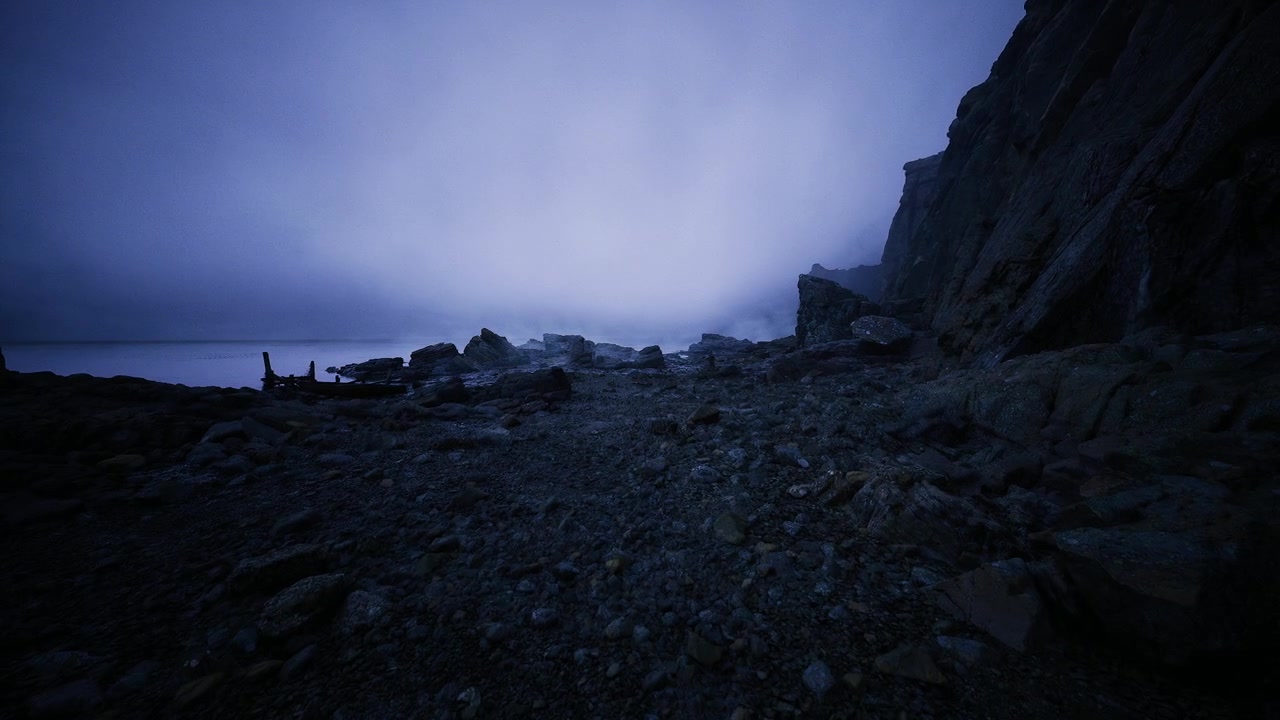 Calm twilight at pebble beach with wet shining rocks and gentle waves