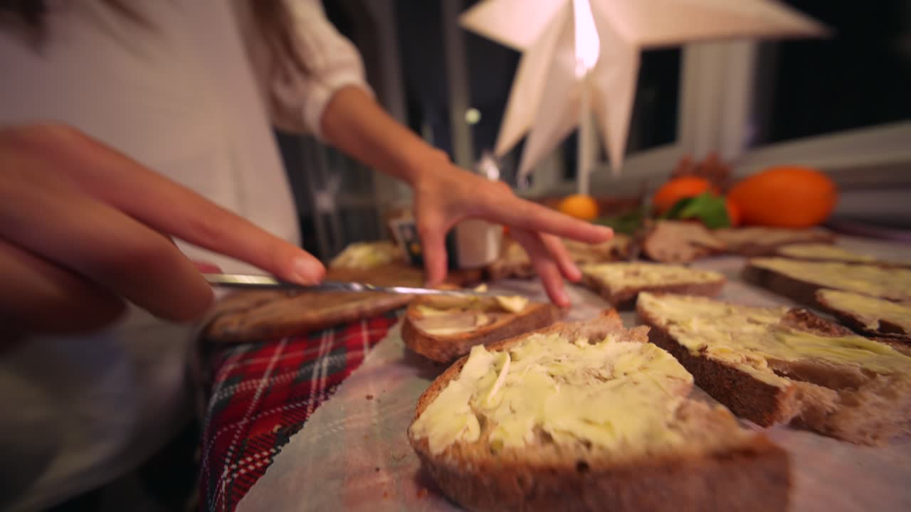 Person Spreading Butter on Slices of Bread in a Cozy Kitchen