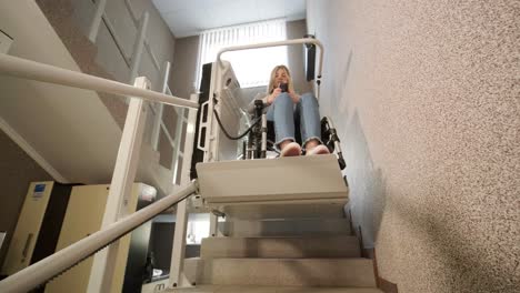 una niña en silla de ruedas sube las escaleras sin esfuerzo usando un ascensor de escaleras.