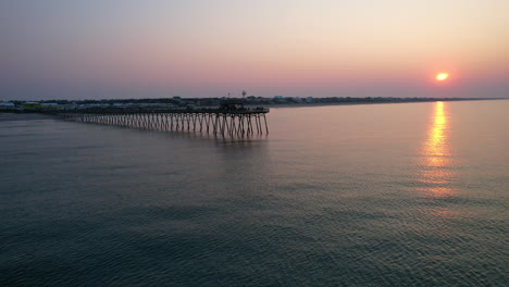 Drohne-Des-Bogue-Inlet-Piers-Mit-Ruhigem-Meer,-Während-Die-Sonne-Aufgeht