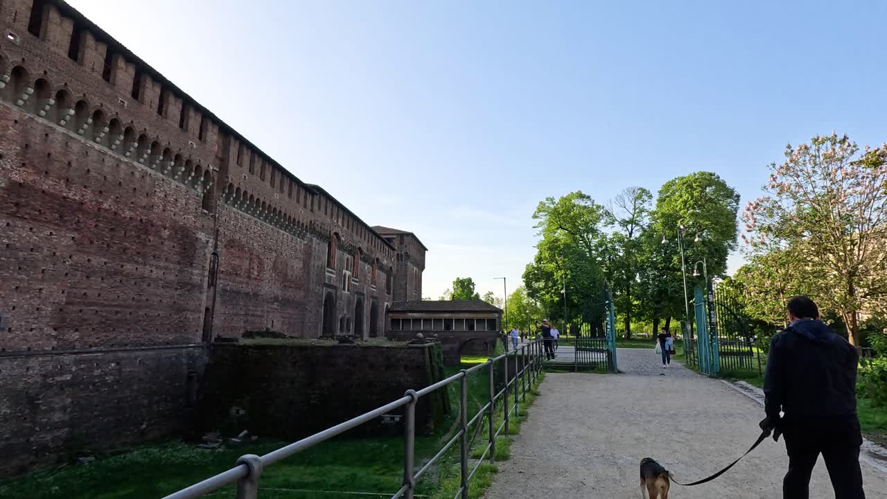 성 길 을 따라 개 를 산책 시키는 사람