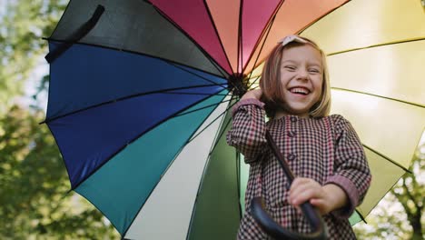 low angle view of happy girl with colorful umbrella