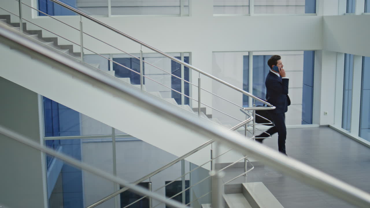 Professional walking down stairway talking cellphone. Successful businessman