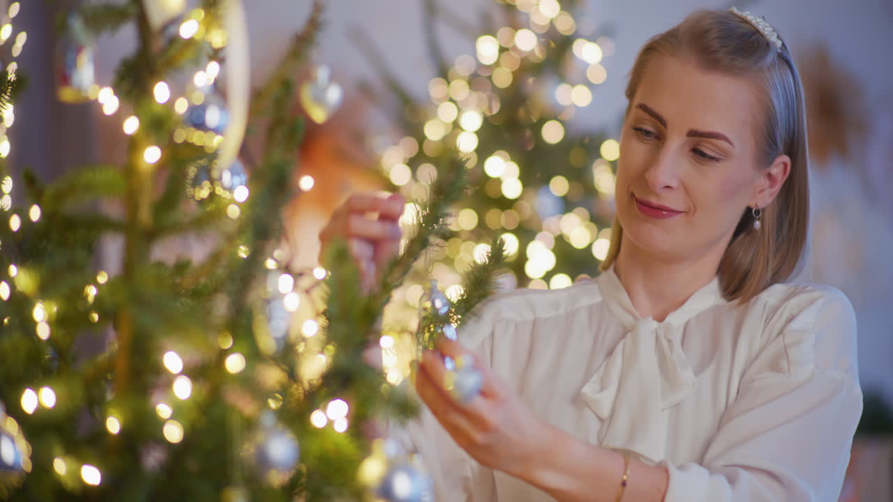 una mujer elegante decorando el árbol de navidad.