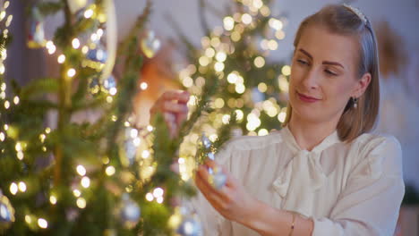 beautiful elegant woman decorating christmas tree