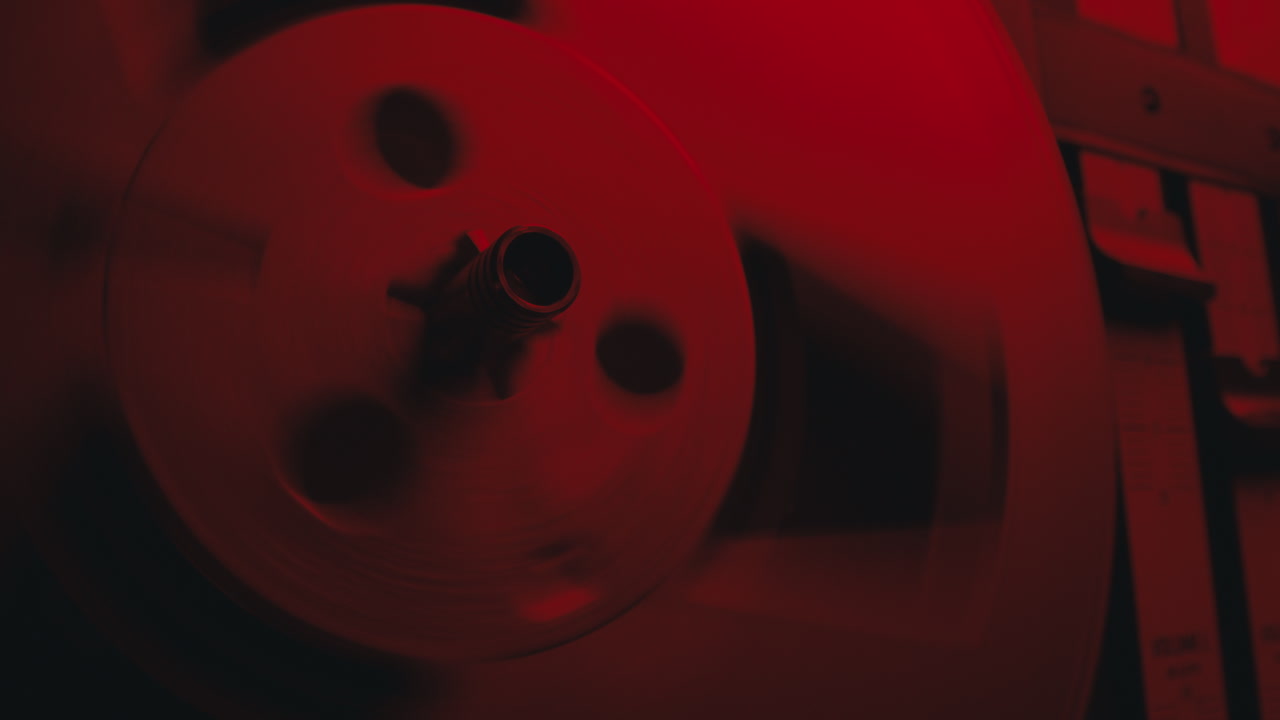 Un gros plan sur un magnétophone vintage dans une lumière rouge clignotante.