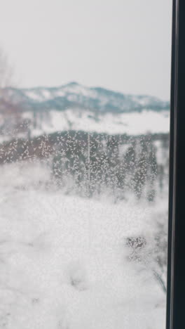 scenic mountains landscape opens from big panoramic frozen window of country house. cloudy winter day in highland of gorny altai covered with snow