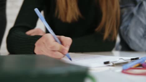 vista de cerca de diversos estudiantes multiétnicos escribiendo y examinando en la escuela o la universidad. prueba en la escuela. toma en cámara lenta