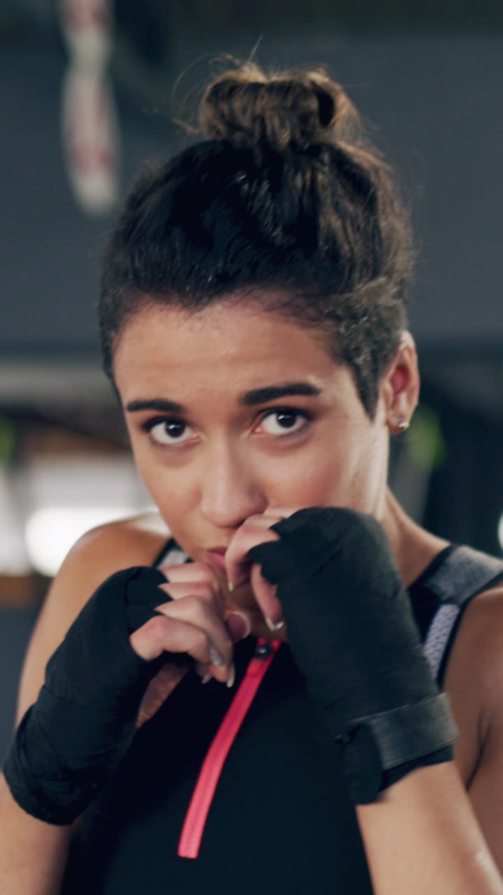 Giovane donna determinata che fa shadow boxing e si allena in palestra