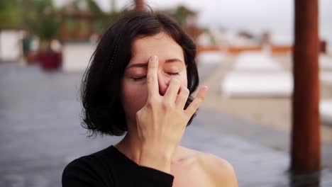 Mujer-Practicando-Ejercicio-De-Yoga-Sentada-En-Pose-Sukhasana,-Realizando-Técnicas-De-Respiración-Nasal-Al-Aire-Libre