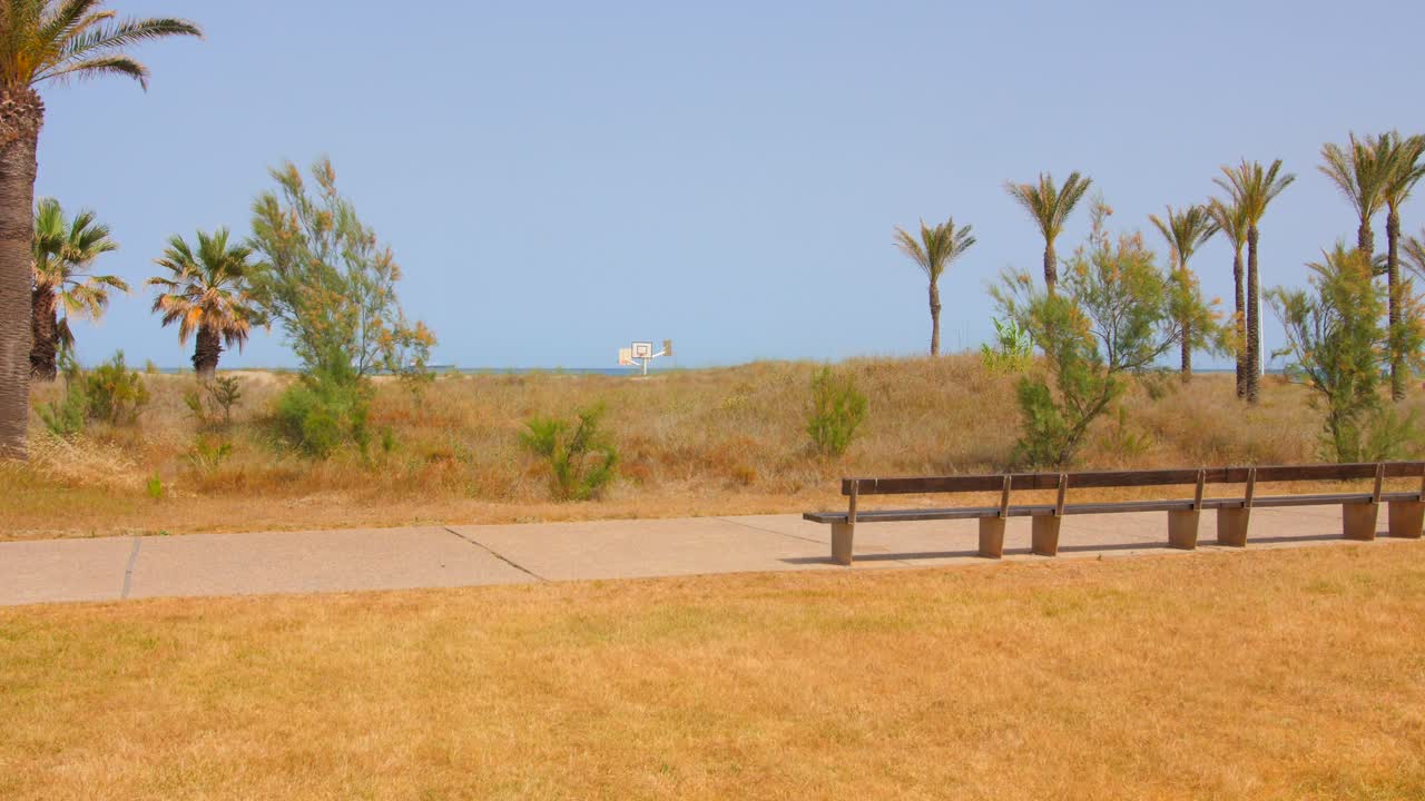 banco de madera vacío en el paseo marítimo con vistas al mar azul durante el verano