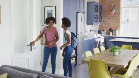 happy african american mother and daughter entering house