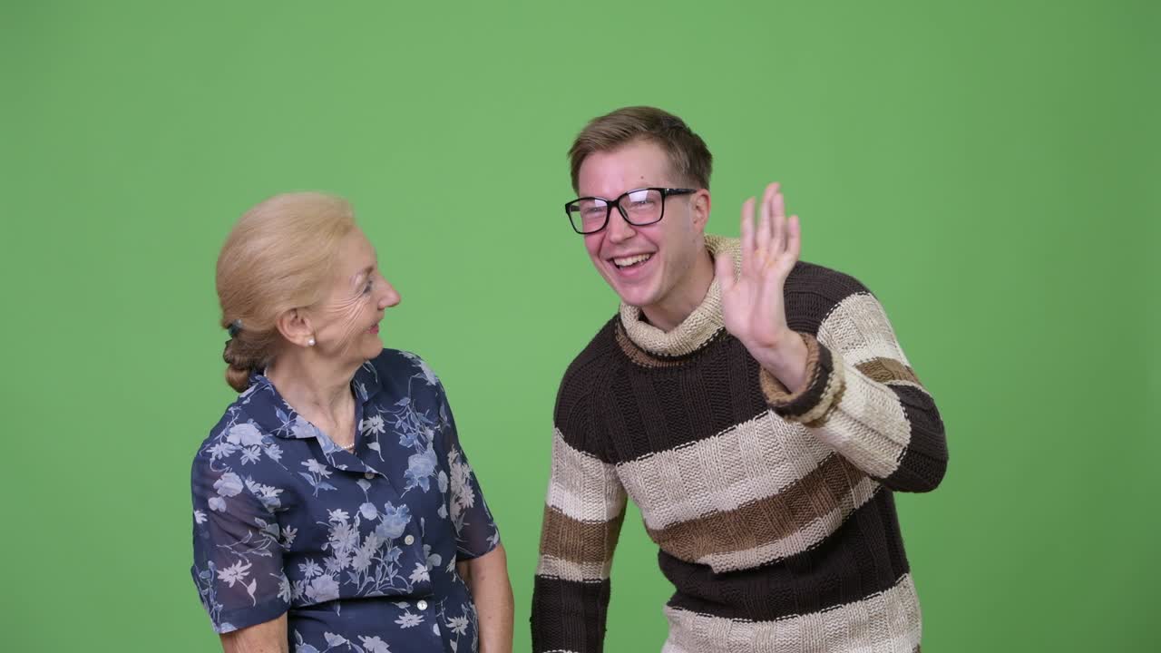 Happy grandmother and grandson greeting together