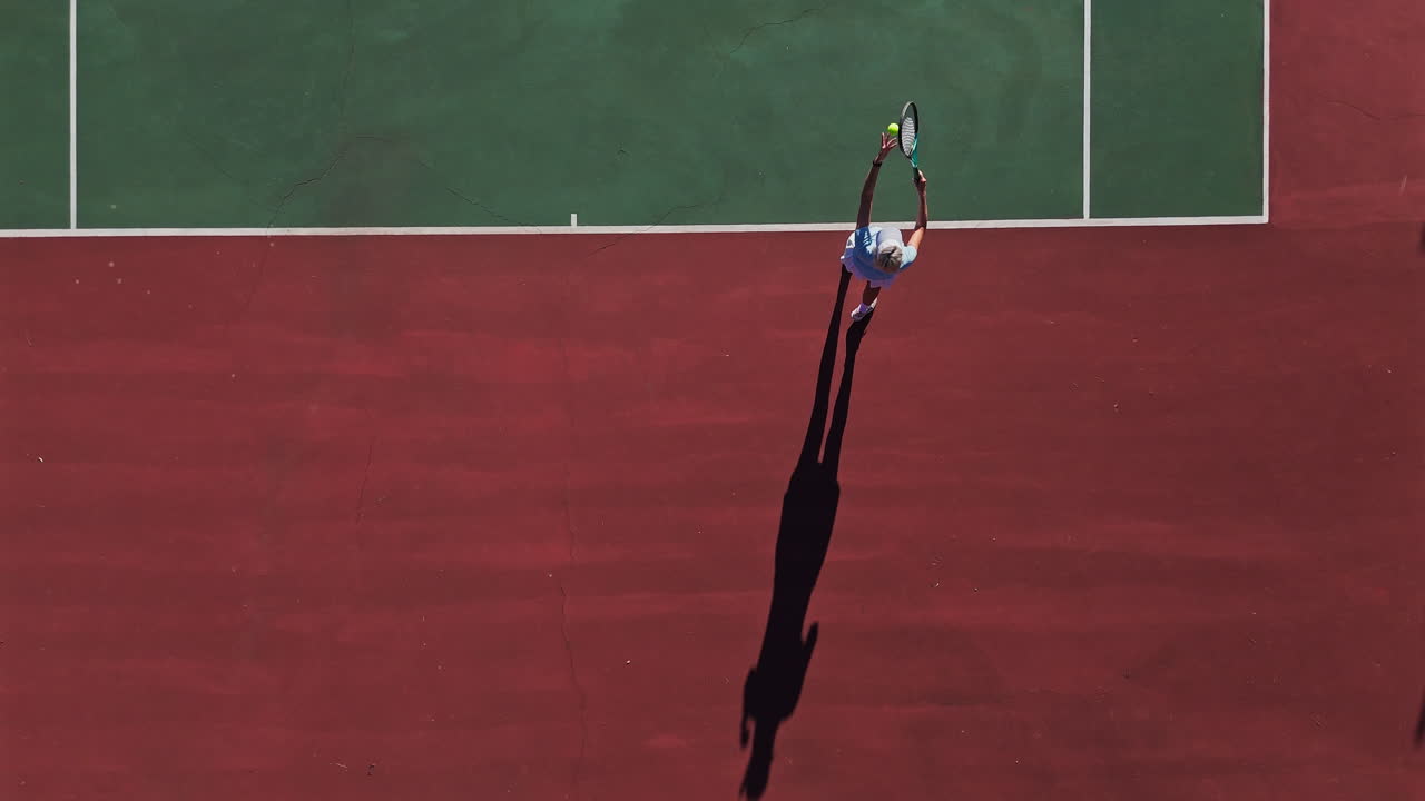Overhead shot of a tennis player serving on a tennis court