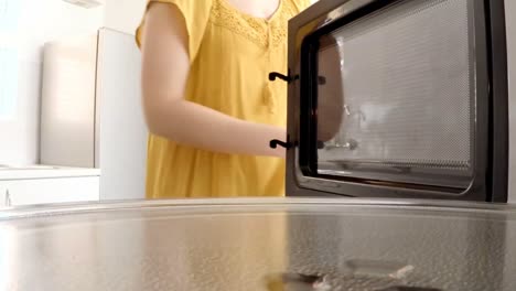 woman putting a baking pan with sweet food to bake in oven