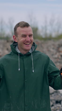 happy man without gas mask breathe in ruined place. ecologist in protective suit without respirator satisfied with a normal level of air after the chemical attack outdoors. vertical video
