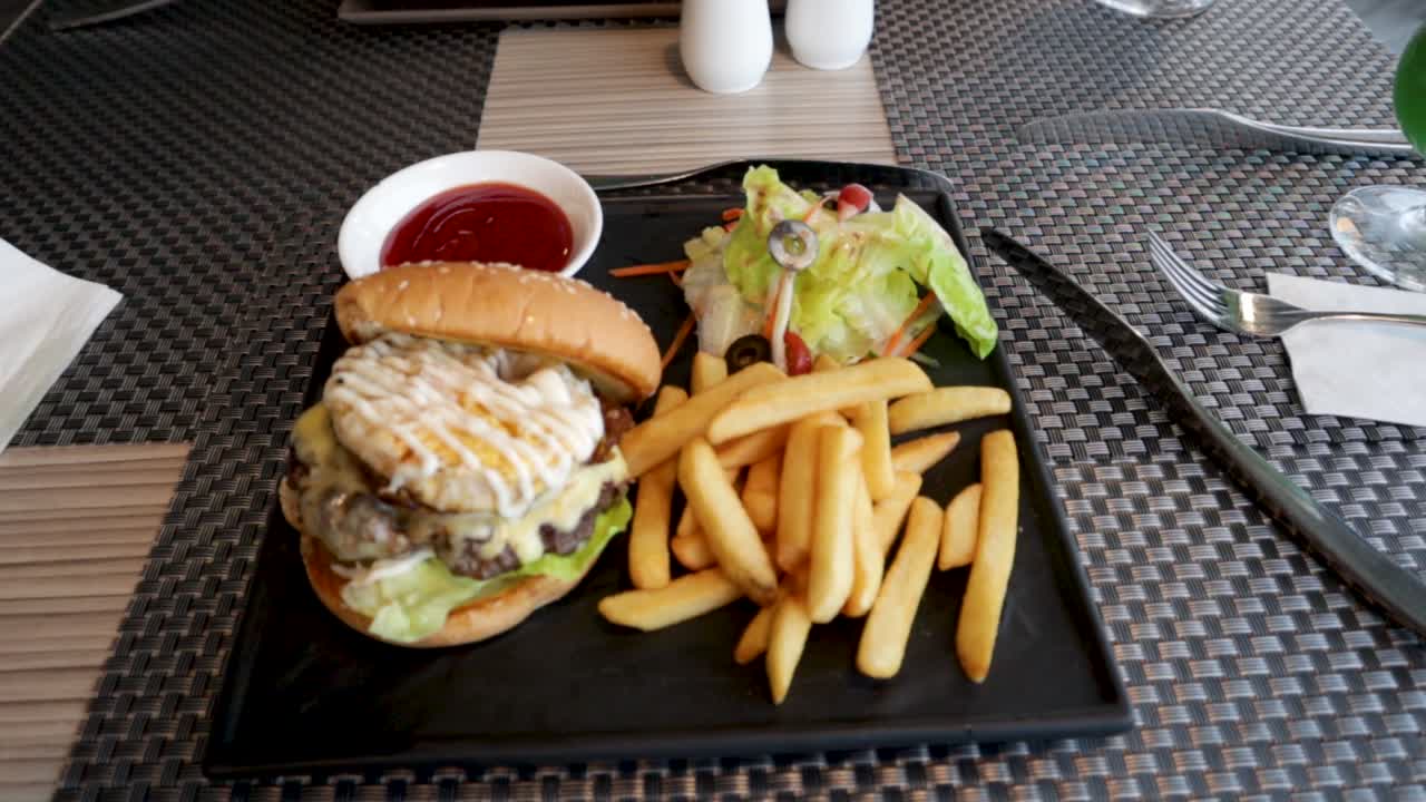 아름다운 검은색 슬레이트 접시에 맛있는 버거와 감자튀김