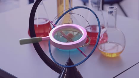 animation of magnifying glass over lab flasks