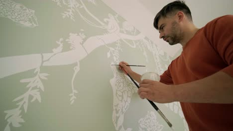 el artista está decorando las paredes con dibujos en la habitación de los niños. pintura de arte de las paredes en la casa nueva. trabajos de reparación.
