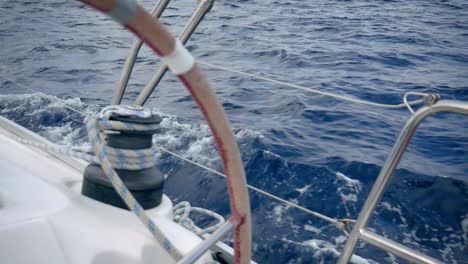 timón y cabrestante de un velero navegando por el mar azul - un primerísimo plano