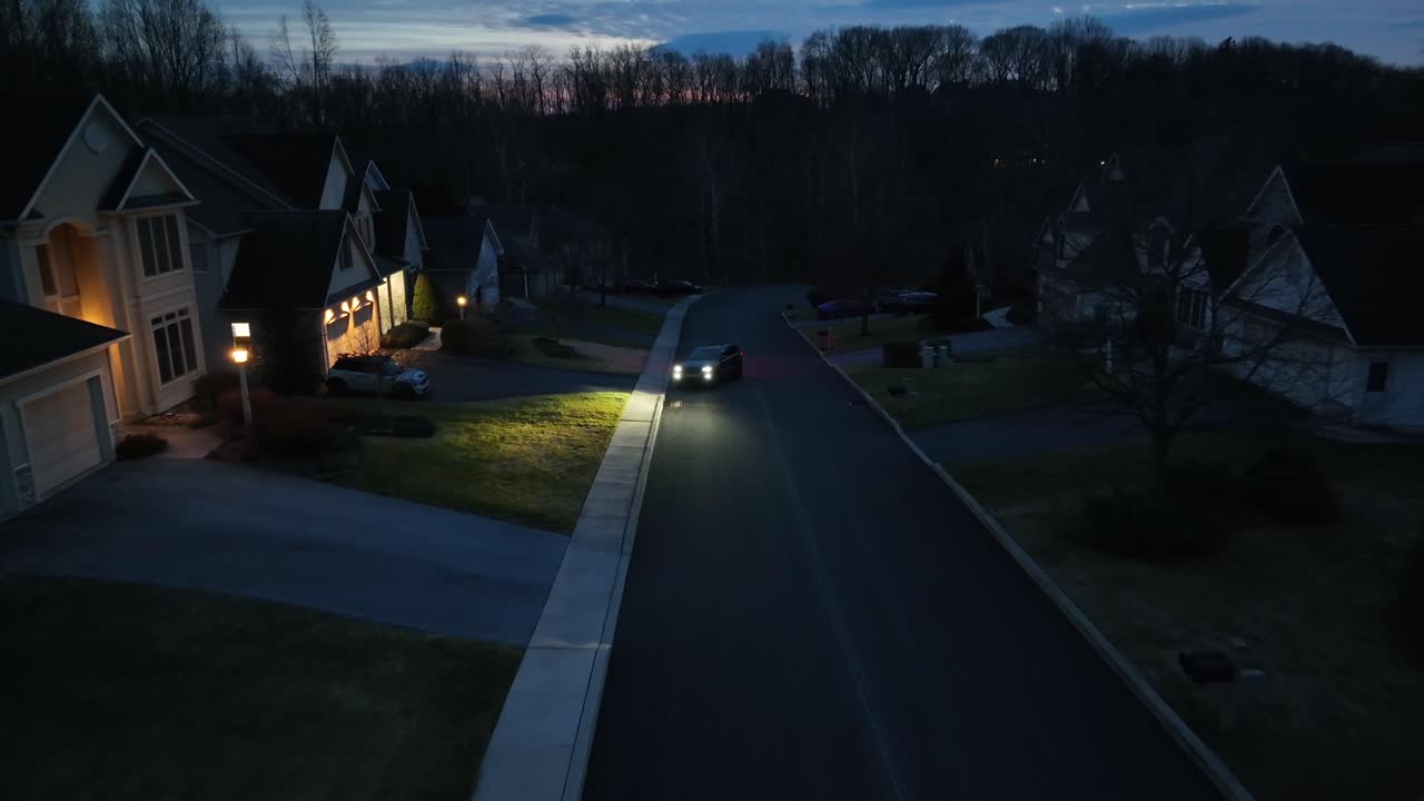 밤에 미국에서 큰 동네에 주차 된 헤드 라이트와 함께 자동차