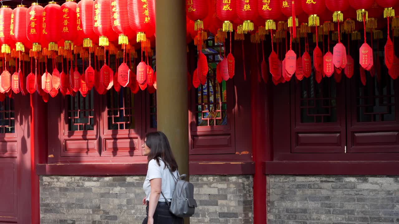 Woman walks under red lanterns at Giant Wild Goose Pagoda, Xian