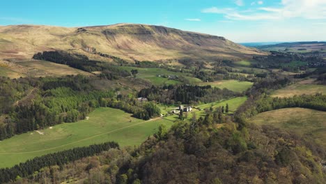 panoramic aerial view of a historic valley landscape with mountains and forest