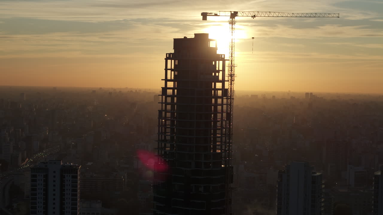 Aerial view of Silhouette of skyscraper under construction with crane at sunset, Buenos Aires, Argentina.
