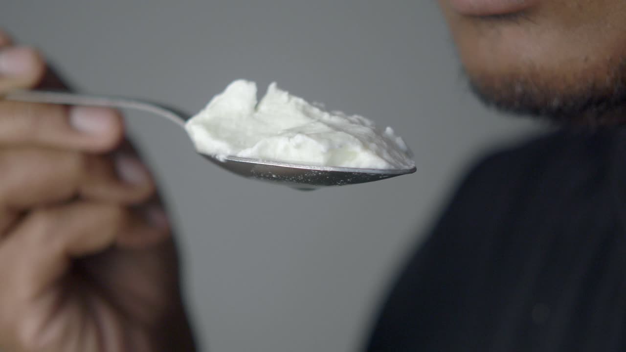 Person eating yogurt from a spoon