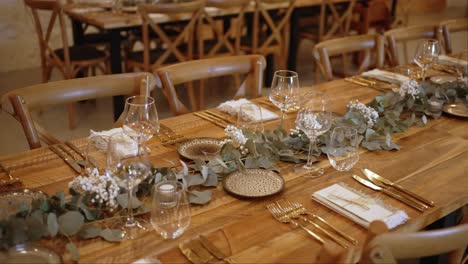 elegant rustic wedding dinner table setting with glassware gold cutlery and floral decor
