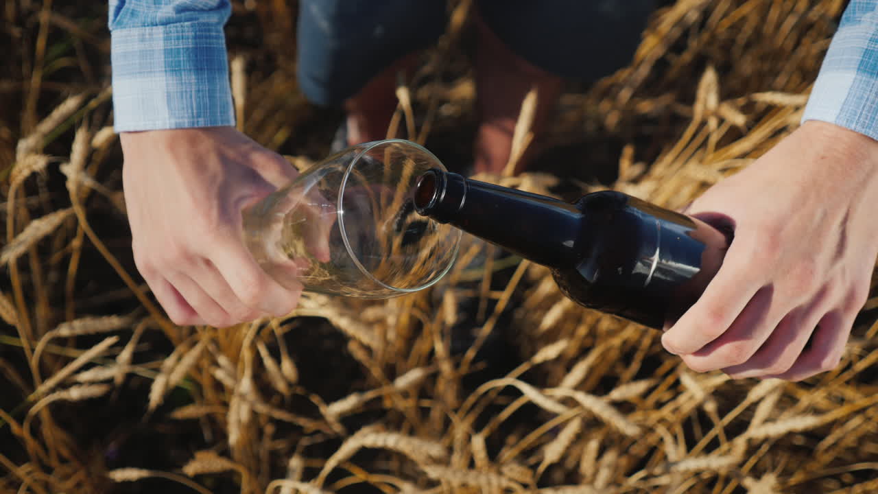 한 남자가 병에서 유리잔에 맥주를 따른다 1