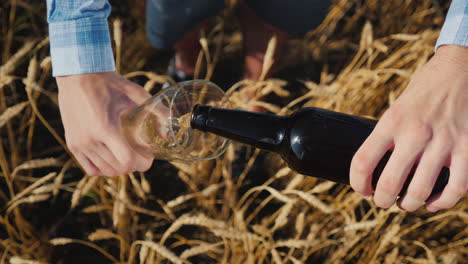 a man pours beer from a bottle into a glass 1