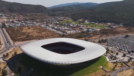 aerial backwards shot of estadio akron stadium of club deportivo guadalajara in scenic area in mexico