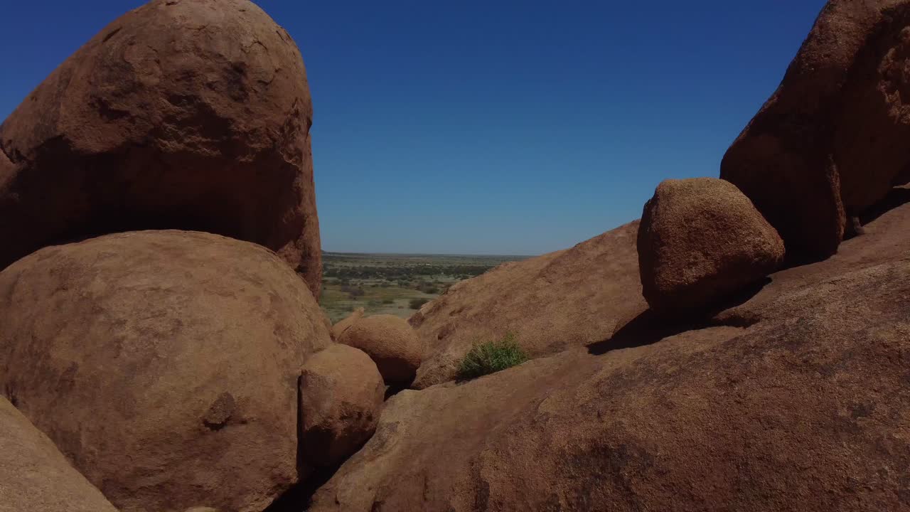 Drone shot of Spitzkoppe in Namibia - drone is flying through a natural stone formation. Snippet could ideally be used for travel or nature related movies or Namibia videos.