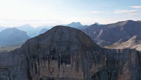 Bathed-in-the-golden-hue-of-the-sun,-the-towering-Heiligkreizkofel-in-Val-Badia-offers-an-awe-inspiring-sight,-with-its-sheer-rock-faces-juxtaposed-against-the-vastness-of-the-horizon